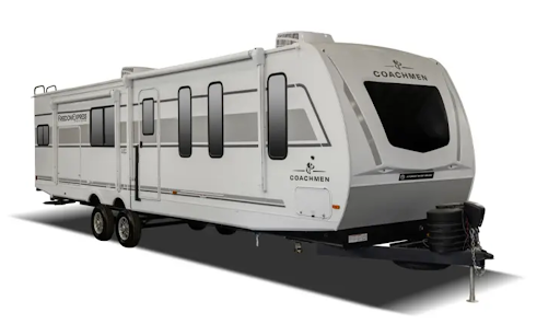 unnamed (16) A large, modern white travel trailer with multiple windows, dual axles, and an extended awning, labeled “Coachmen” on the front and side, displayed on a white background.